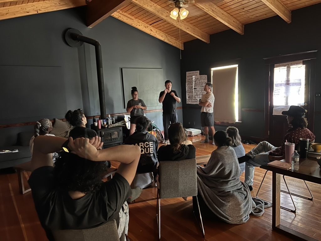Artists gathered for a signed discussion in a wood-beamed studio